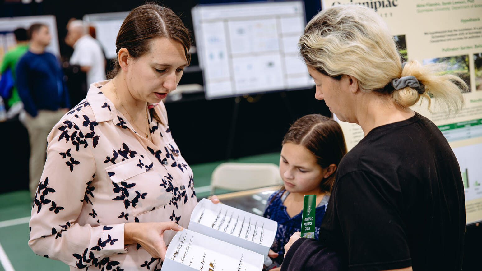 Exploratorium attendees observe bugs at a pollinator exhibit.